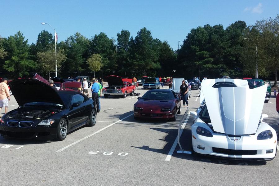 Participants at the Muscle and Classic Car Show admire various cars.