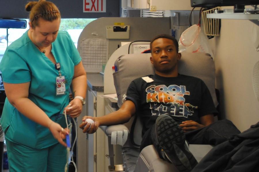 A Rex Healthcare nurse draws blood from Asante Joor at the Key Club sponsored event.