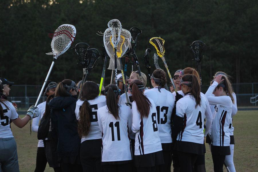 Womens Lacrosse Team shows team spirit during a huddle.