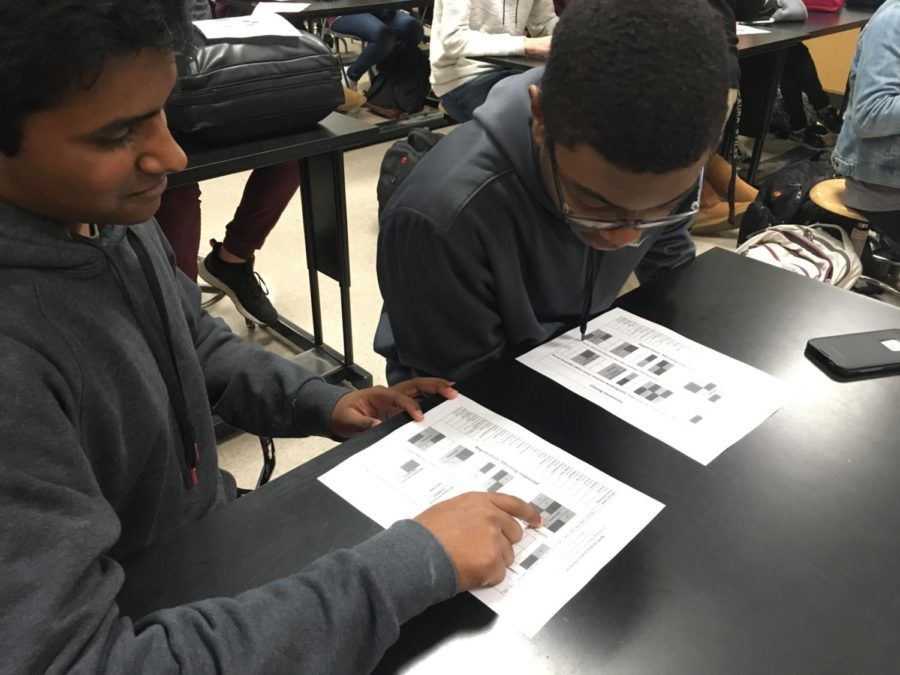 Senior Michael Mathew and Sophomore Emanuel Smith study Science Olympiad schedule.