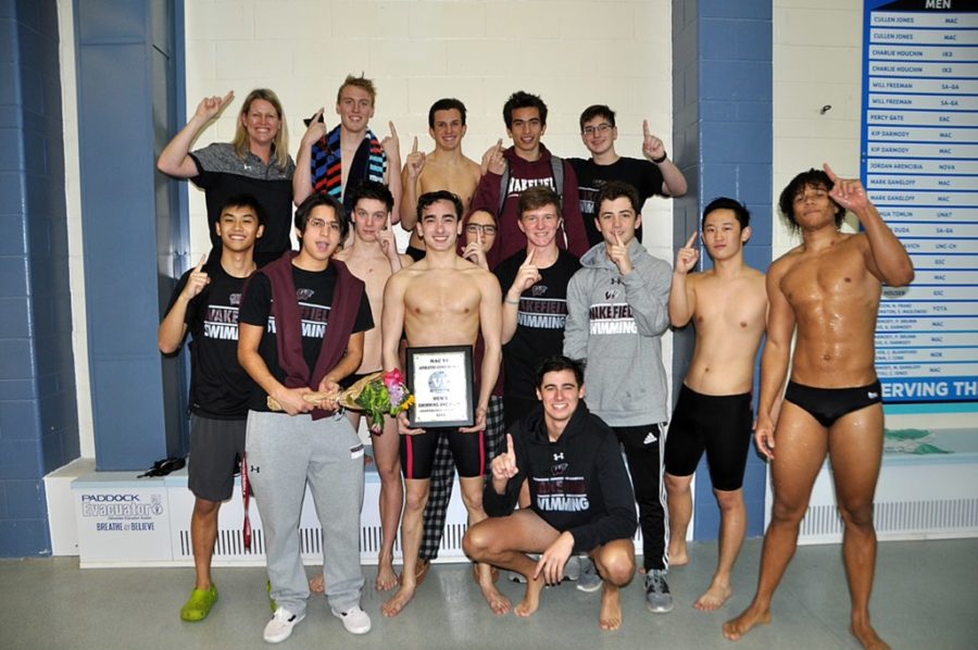The mens swim team poses after winning first place in the Conference Championship meet.