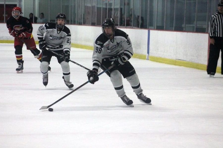 Student, Andrew Robbins, handles the puck for the Eagles hockey team.