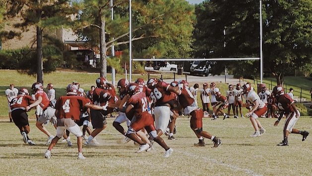 The varsity football team practices their plays for their weekly games.
