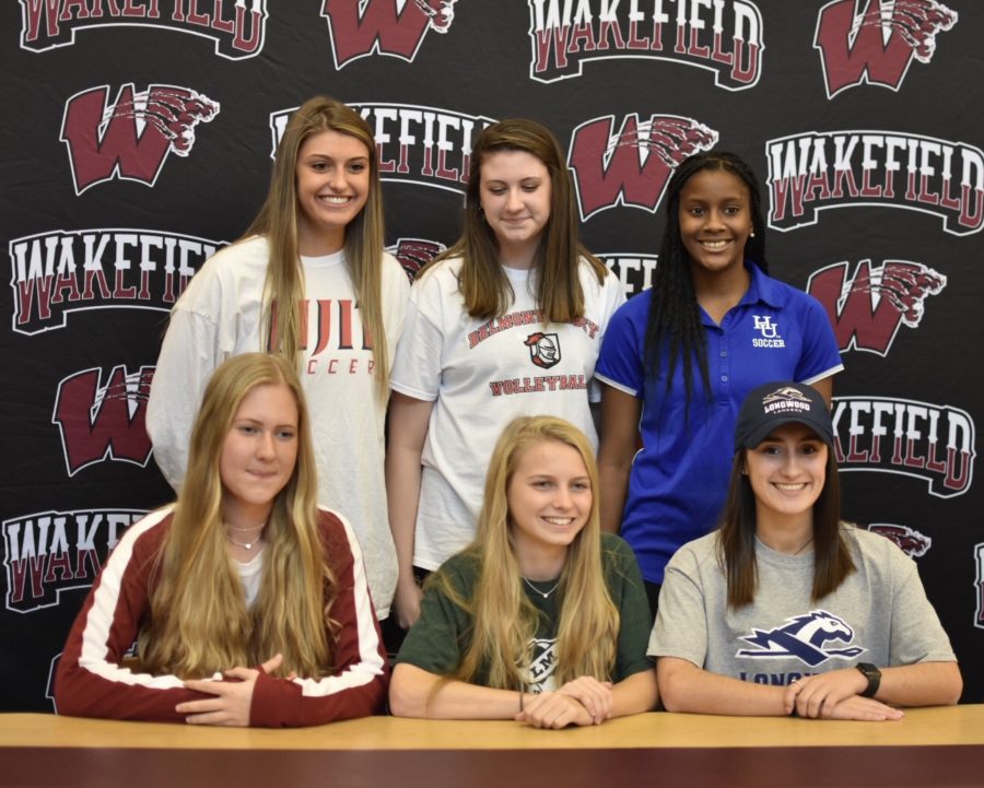 Wakefields signees smile for a picture after signing with their future universities.