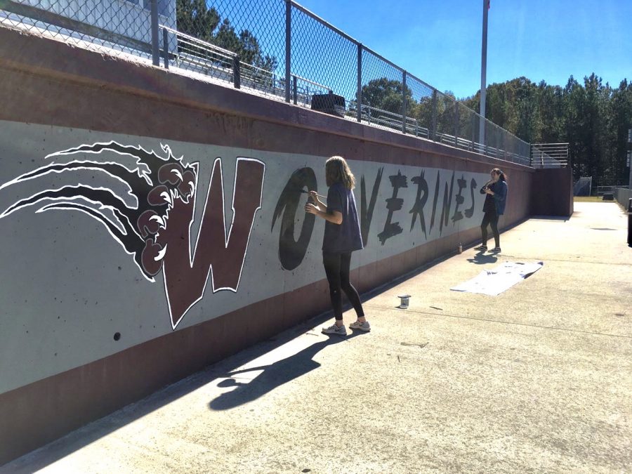 Mira Valentino and Angelina Ramirez finish the fine details of the Wolverine mural. 