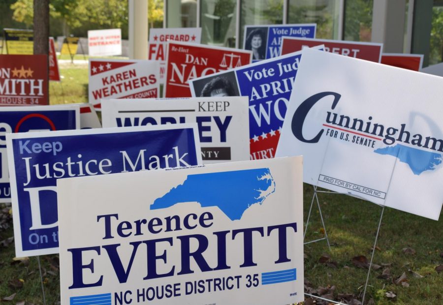 Clusters of campaign signs for local elections sit on the side of an Early Voting building. 