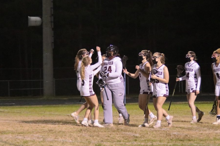 Wakefield women's lacrosse team congratulates their goalie, Ava McLary after a hard-fought game. 