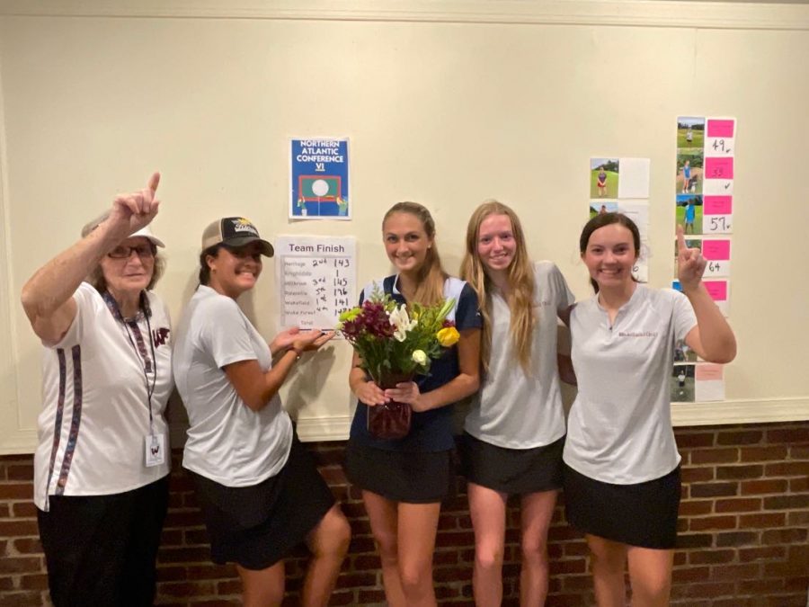Women's golf players smile in front of their first place finish.