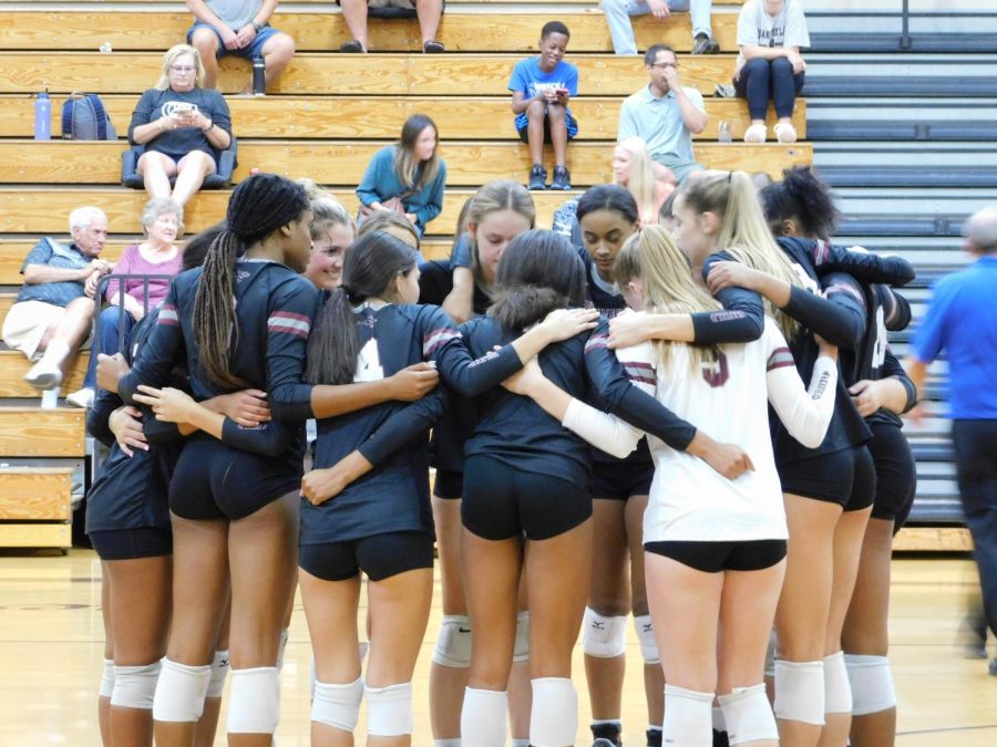 Varsity+volleyball+players+huddled+together+on+the+court+to+prepare+for+their+game+against+South+Campbell.++Players+dominate+on+the+court+at+home+games.