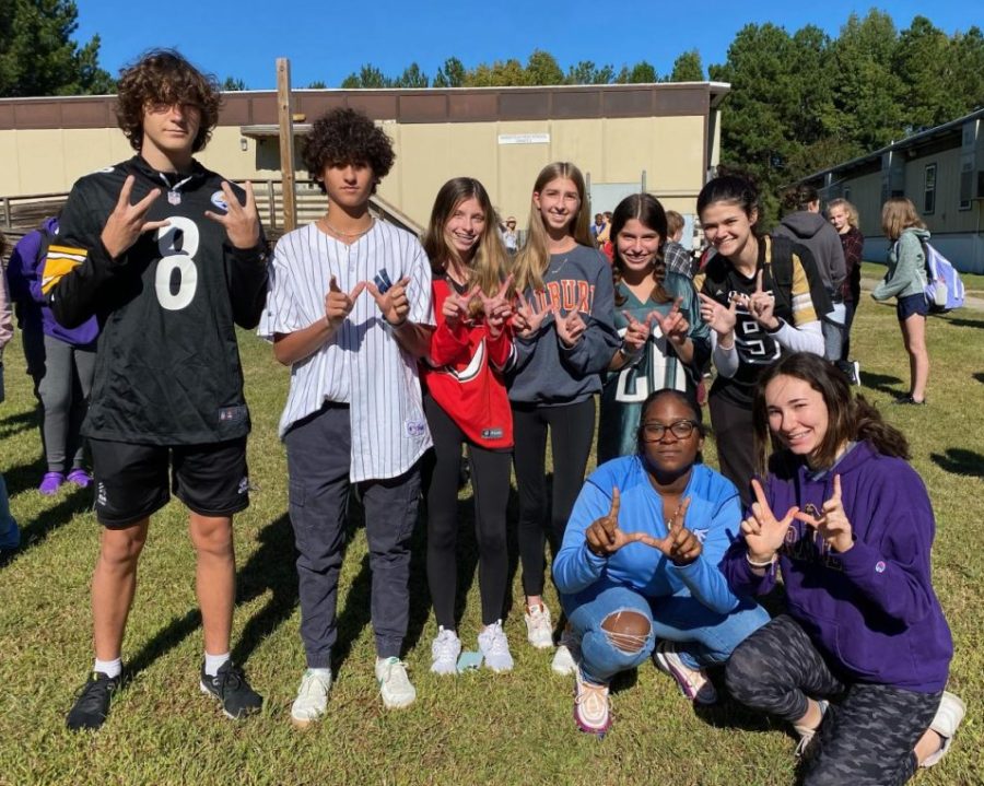 Students pose holding up Ws and showing off their jerseys during Homecoming spirit week (Jersey Day).  This years theme was No Place Like Home.