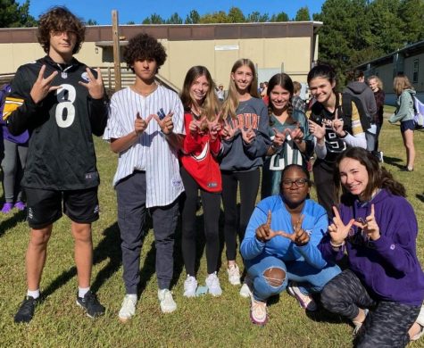 Students pose holding up Ws and showing off their jerseys during Homecoming spirit week (Jersey Day).  This years theme was No Place Like Home.