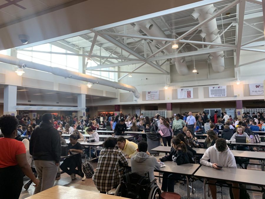Students engage with their peers and move around in the busy cafeteria during Wolverine Hour. Wolverine Hour serves as an opportunity for students to not only enjoy their lunch, but also engage in academic and social activities.