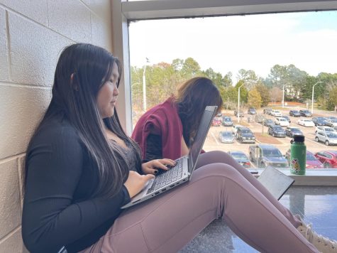 Student writers Angie Lee and Katie Spampinato sit in the hallway on a sunny Wednesday afternoon. Theyre writing their articles for the newest issue on The Howler.
