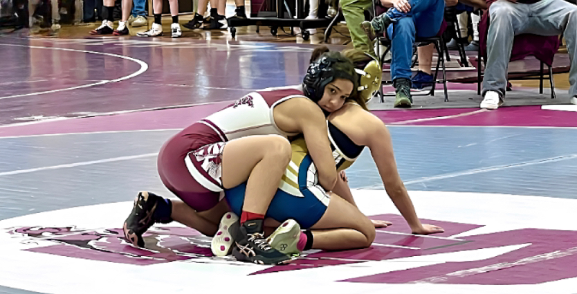 Ava Lytle from the Wakefield Womens Varsity Wrestling Teams wraps her arms around her opponent preparing for round two of her match against Fike High School. Lytle won the match and won first place overall for her weight class at the Jan. 7 wrestling tournament. 