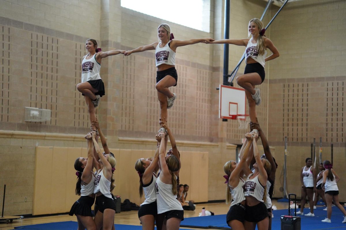 Wakefields varsity cheer team practices stunts for the upcoming pep rally and homecoming game. The homecoming game will take place Sept. 29.