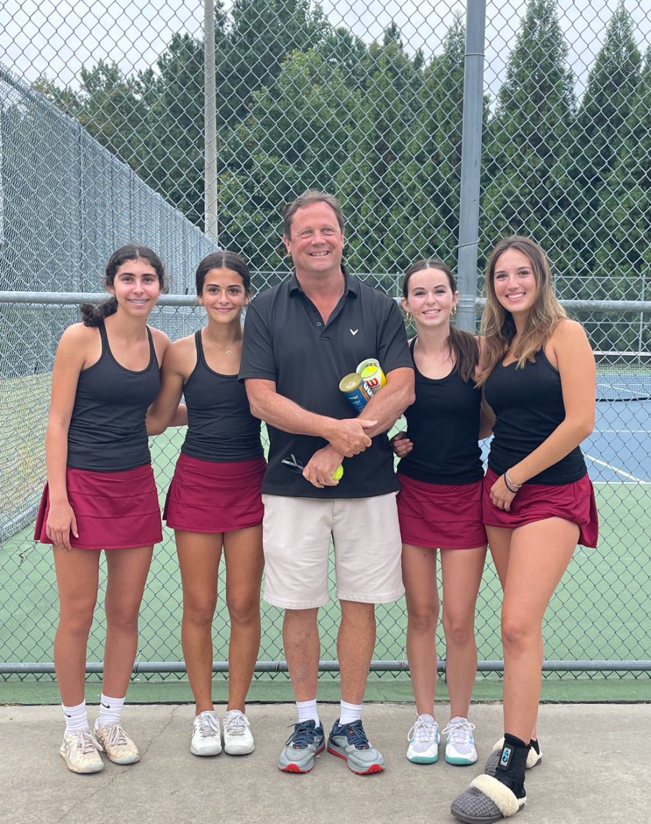 Elsa Weiner, Maya El-Kaissi, Coach Stewart, Maya Raftery, and co-captain Sophie Hanna line up for a picture at one of their matches. The close nature of this team drives the team to success both on and off the court. 
(Photo Courtesy of Julie Raftery)