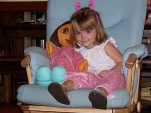 Jordan McIntyre sitting in her favorite chair at grandmas house. She was always holding her Dora or Mickey Mouse stuffed animal.