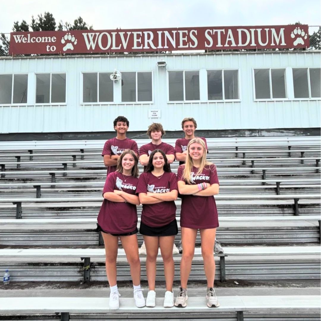 Six of the Head Wackos pose for a photo on the bleachers of the stadium. They prepare for an exciting new year. (Photo courtesy of Wakefield Wackos) 