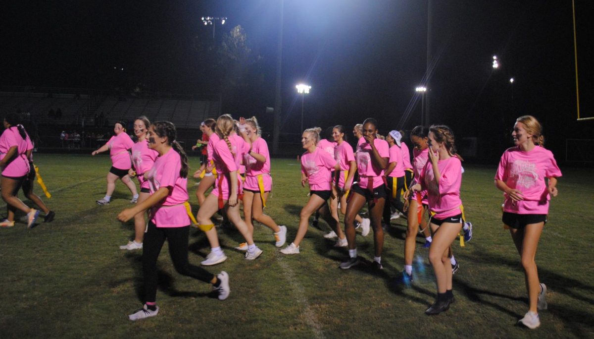 The Juniors run onto the field with excitement ready to start the Junior vs. Senior Powderpuff match. It is a highly anticipated game that many enjoy.