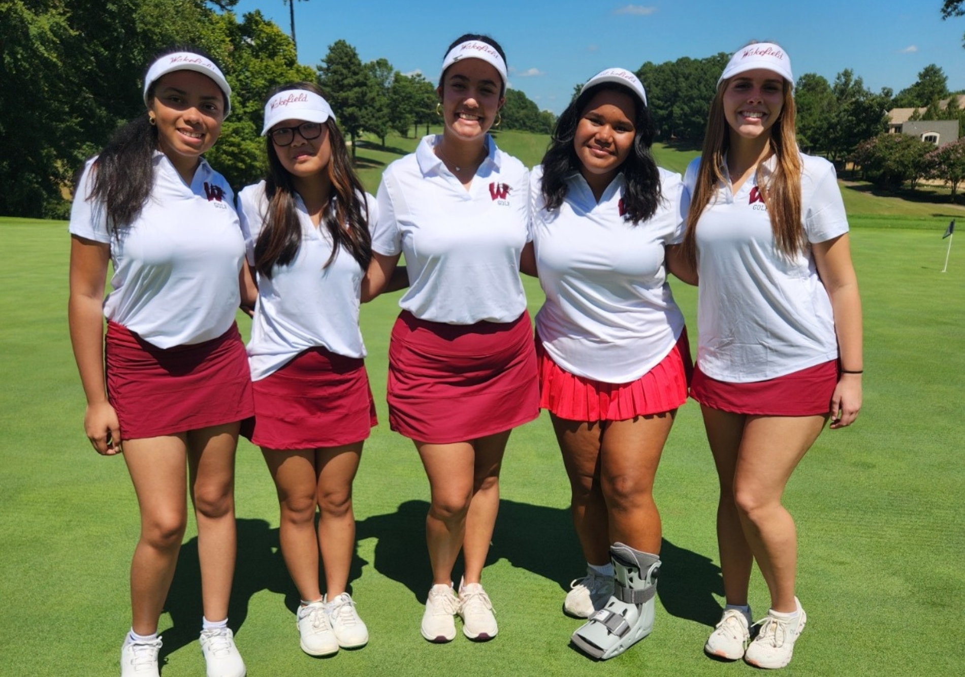 The Wakefield Women's golf team poses for a picture during a match. The girls work hard to lower their scores and build lasting connections. (Photo courtesy of Arieliz Reyes)